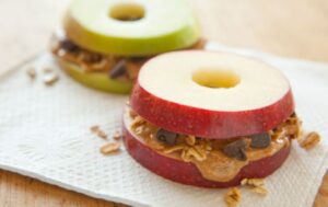 Apple slices sandwiching seed butter and granola